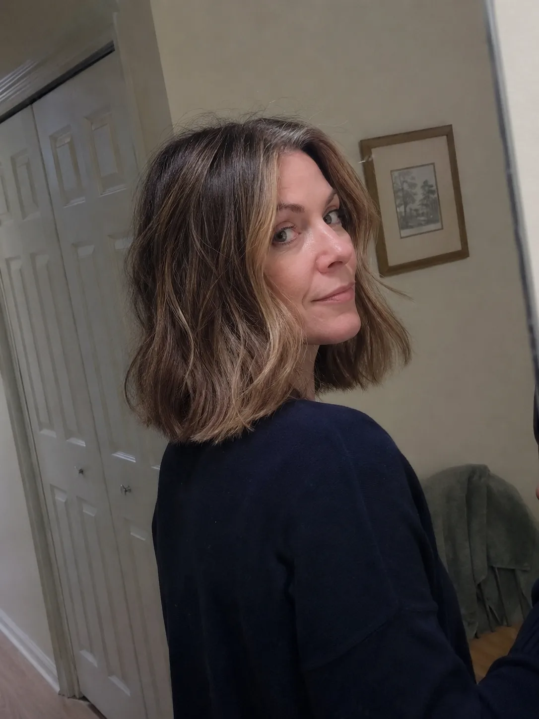 A blunt-cut, shoulder-length lob styled with relaxed, lived-in bends that keep structure and weight on frizzy hair
