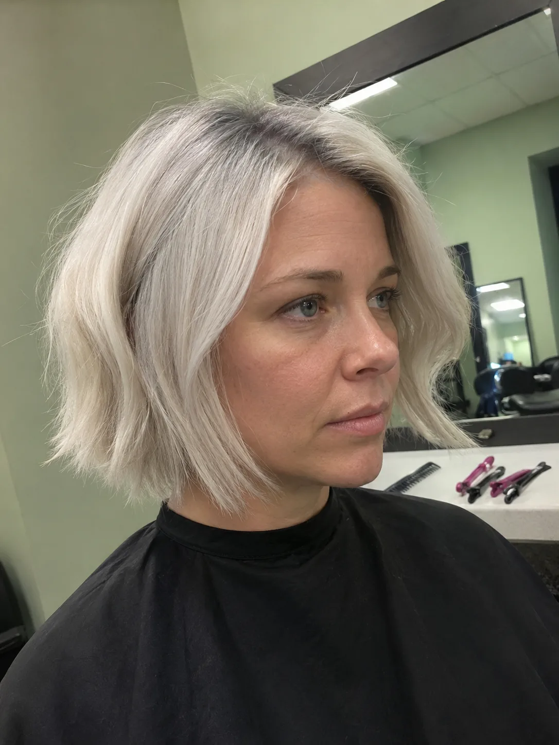 A chic, textured shoulder-length lob styled with soft waves in a trendy pastel rose gold and dusty pink shade