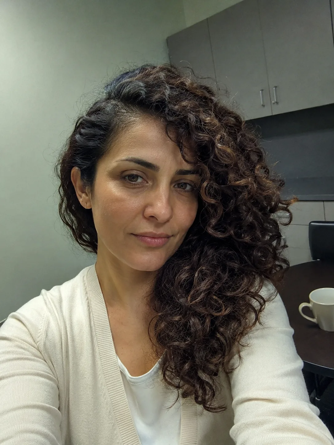 A client with medium-length curly hair showing natural volume and texture