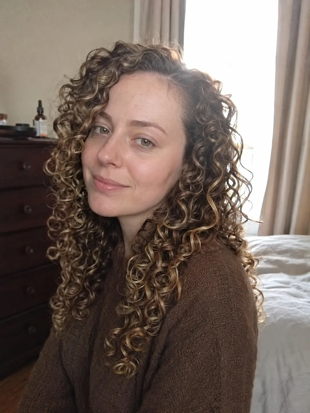 A close-up view of hair showing natural root texture and curl formation