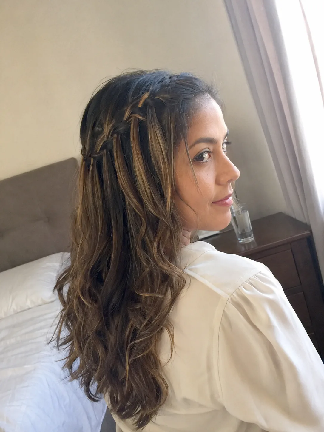 A front-facing portrait of a woman with a straight half up hairstyle