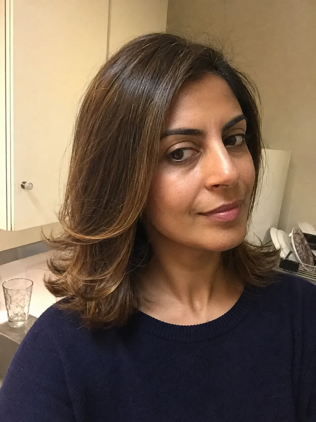 A half-up top knot on medium-length hair illustrating the most forgiving style for this length