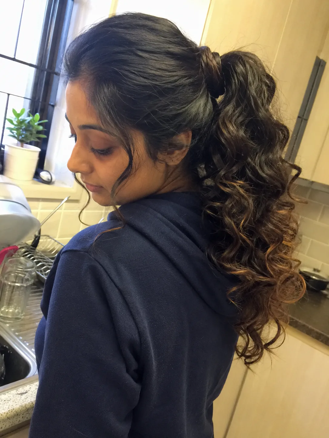 A model with long, curly, well-defined hair to represent the common inspiration clients bring