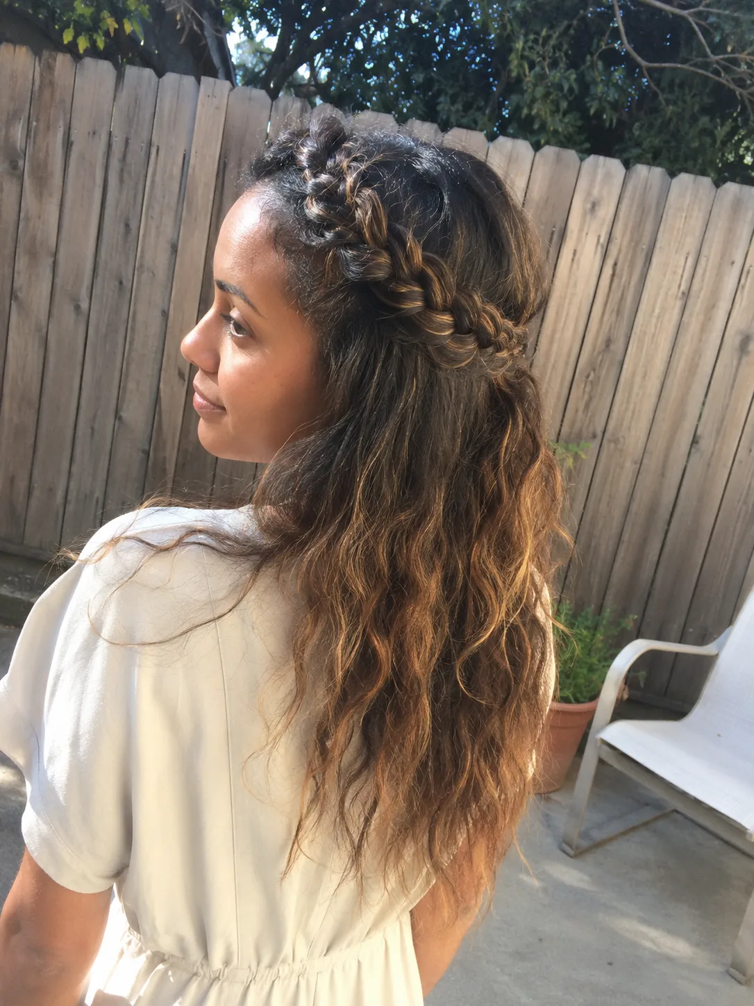 A photo showing transitional collarbone-length hair where the heavy weight pulls the roots flat, leaving the wave pattern struggling to form properly until the mid-lengths