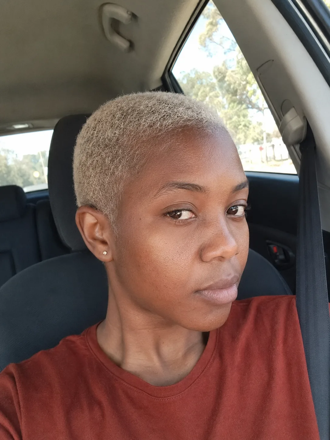 A portrait of a woman looking to the side, showcasing long, straight, and fine hair dyed a solid, uniform platinum blonde