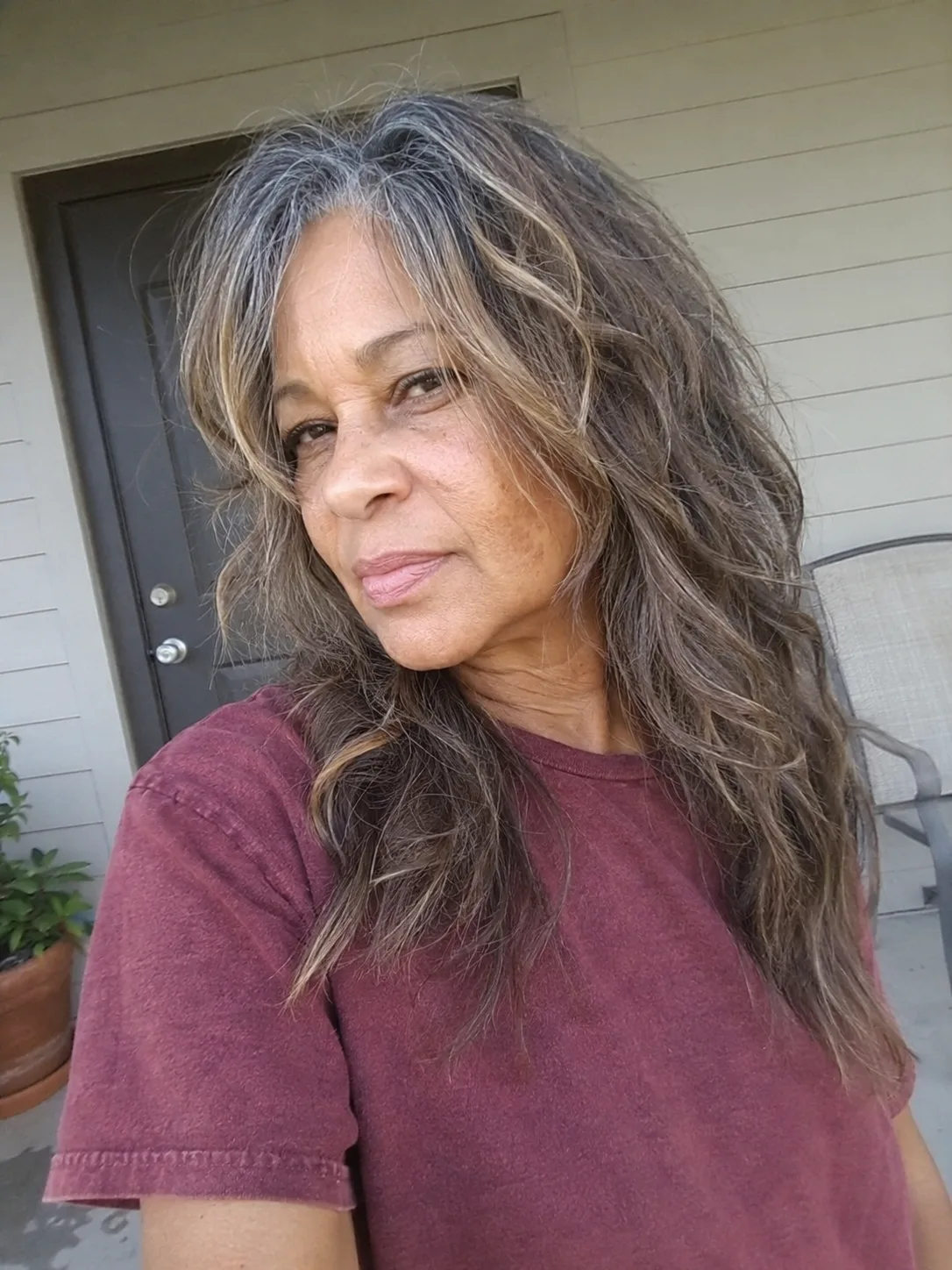 A portrait of a woman with medium-length grey hair featuring well-defined, springy curls