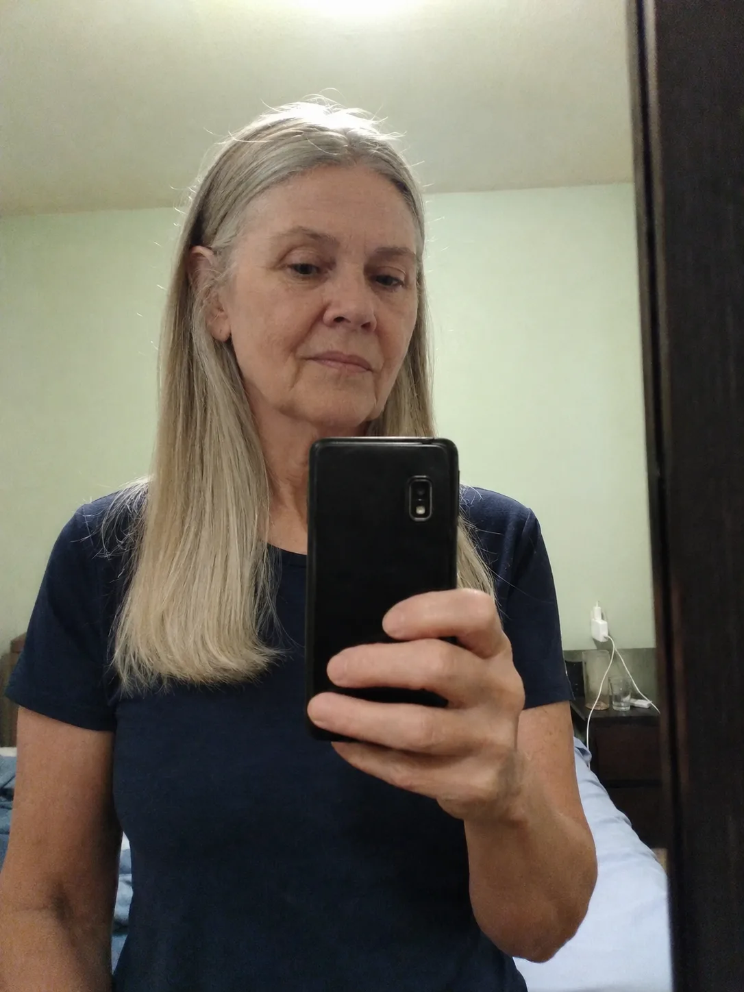 A portrait of a woman with medium-length textured grey waves and a light, wispy fringe