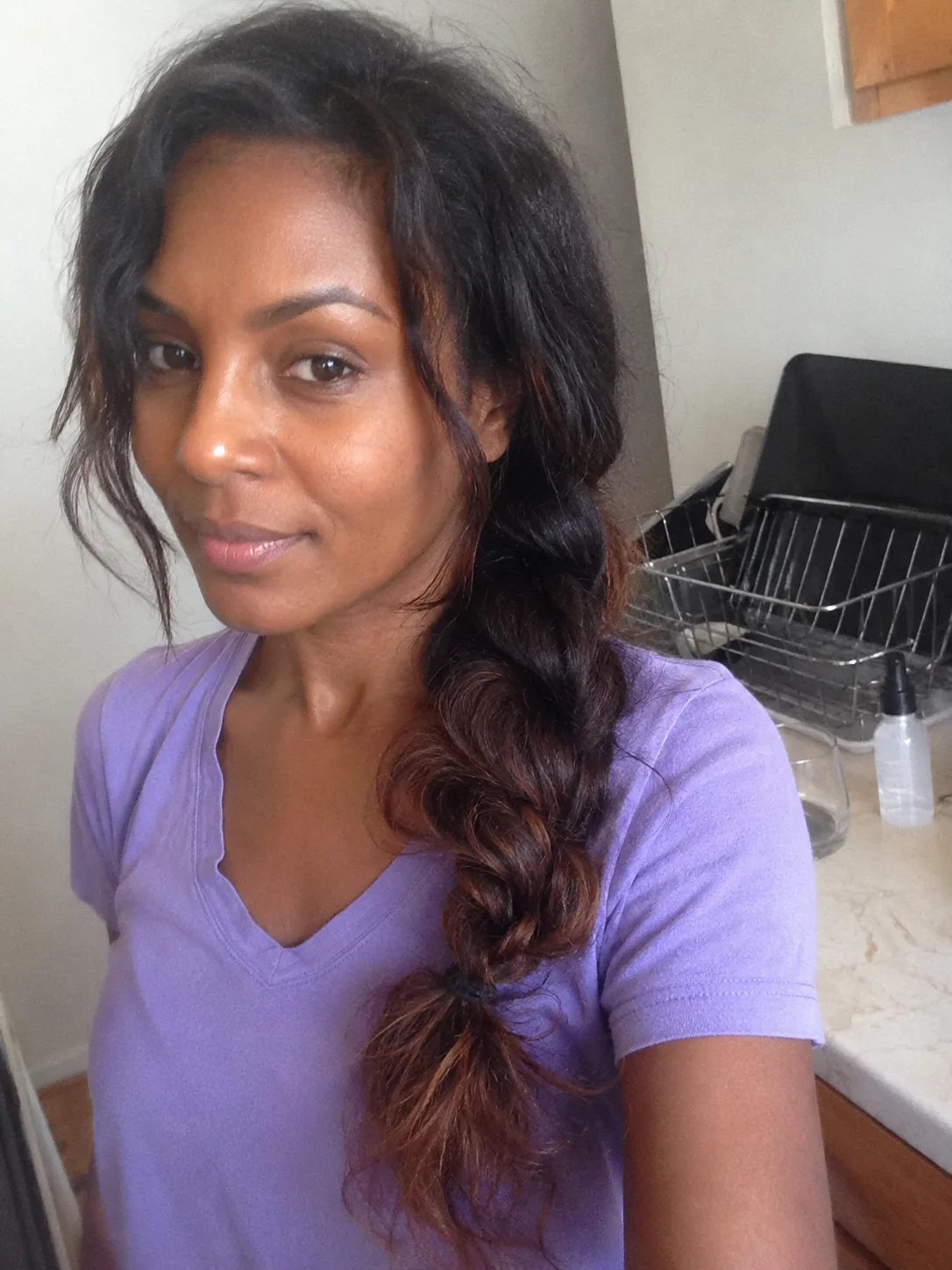 A relaxed, loose side braid pulled over one shoulder, with soft, face-framing waves left out at the front
