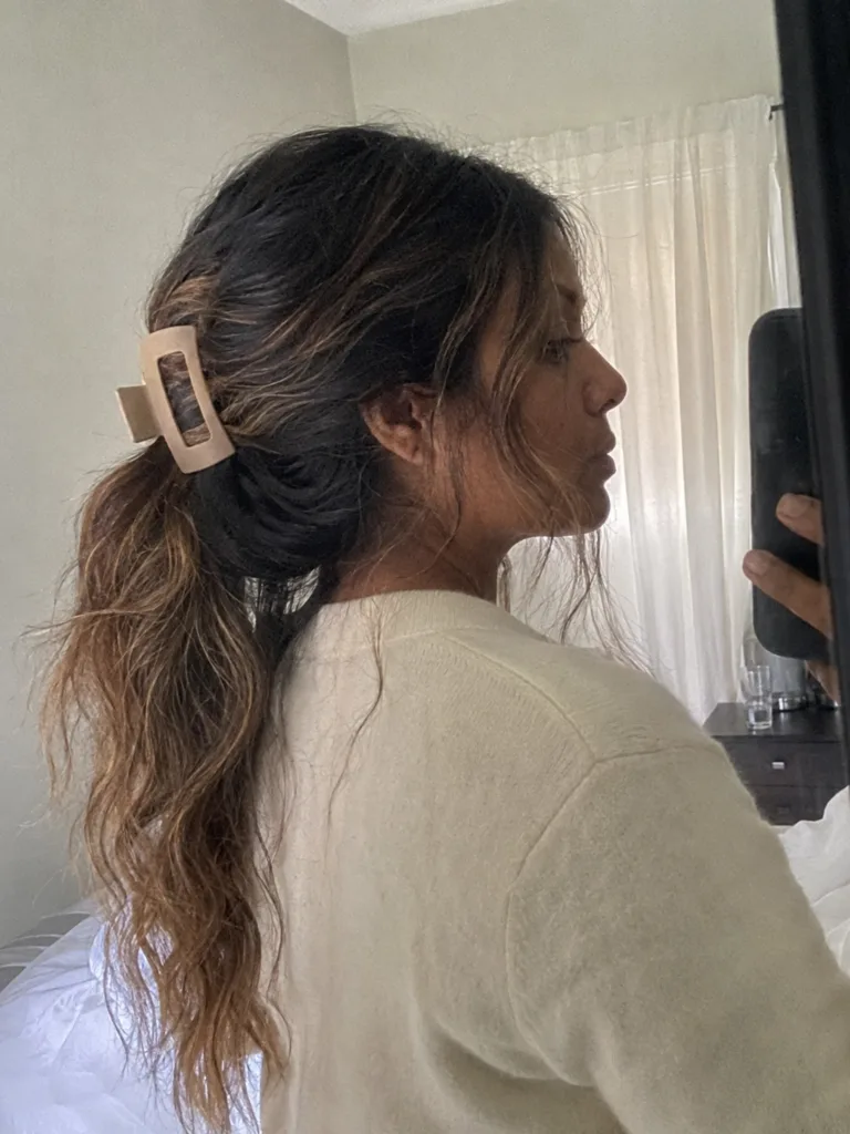 A selfie of a woman with a voluminous, loose, wavy ponytail.
