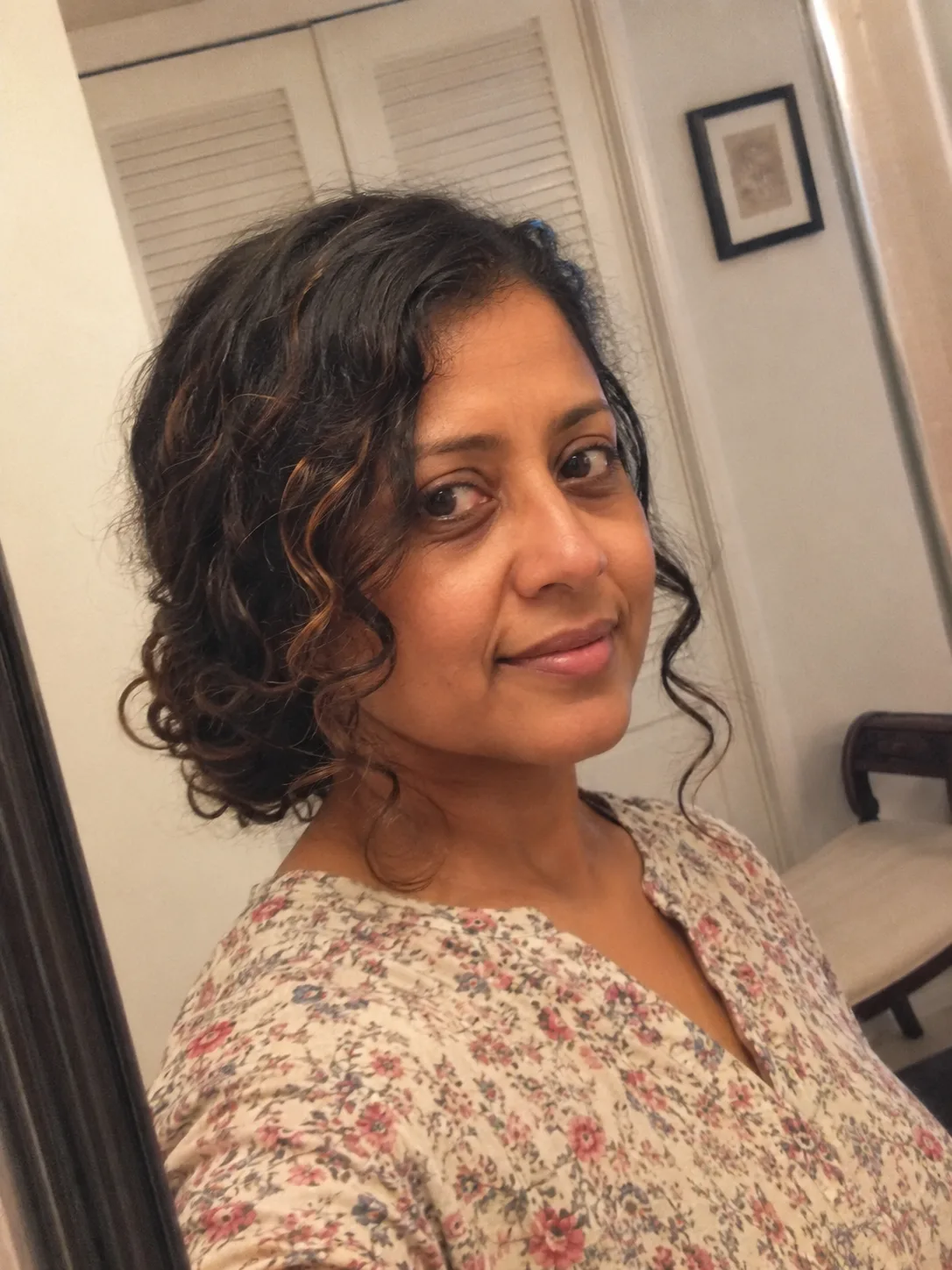 A side profile of a person with a curly faux-hawk style, secured with bobby pins on the side