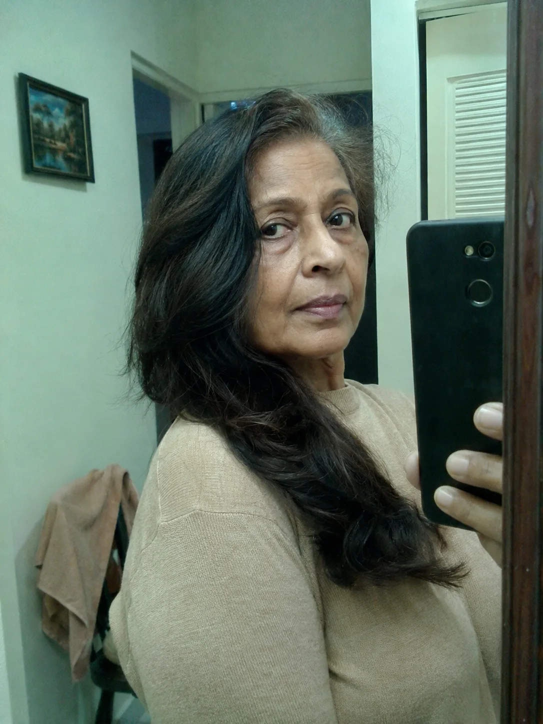 A side profile of a woman with long, sleek silver hair swept smoothly back from the face