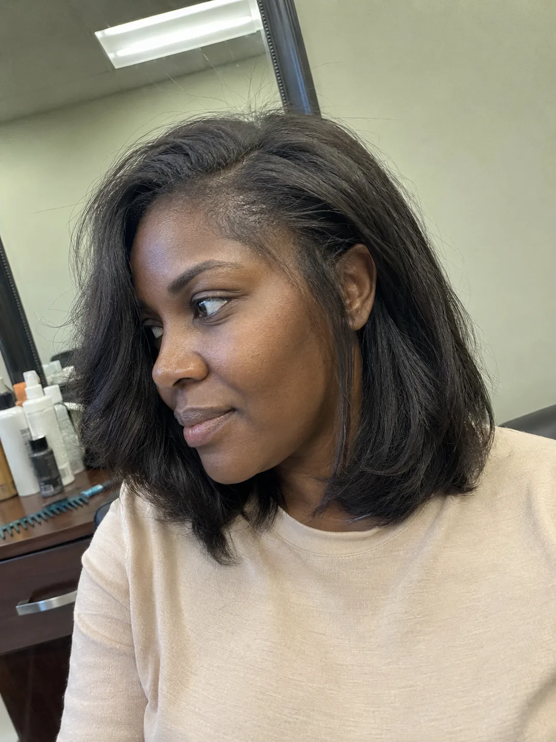 A sleek, side-parted bob cut curving gently at the collarbone, displaying a smooth and voluminous blowout texture that controls mid-shaft puffiness