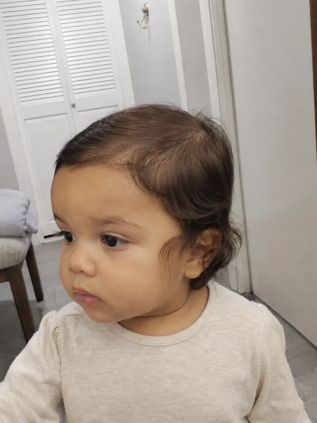 A small, softly wrapped elastic securing the end of a toddler's braid safely