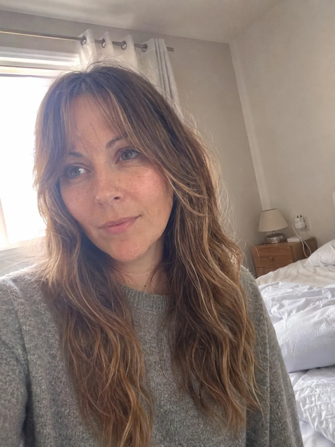 Medium brunette hair with caramel-blonde face-framing highlights.