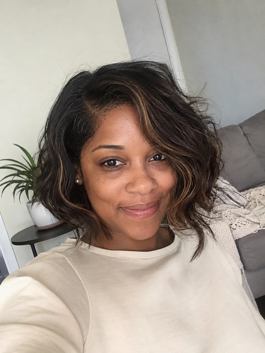 A woman showcasing a luminous, shiny short pixie cut that captures the light without looking flat or chalky