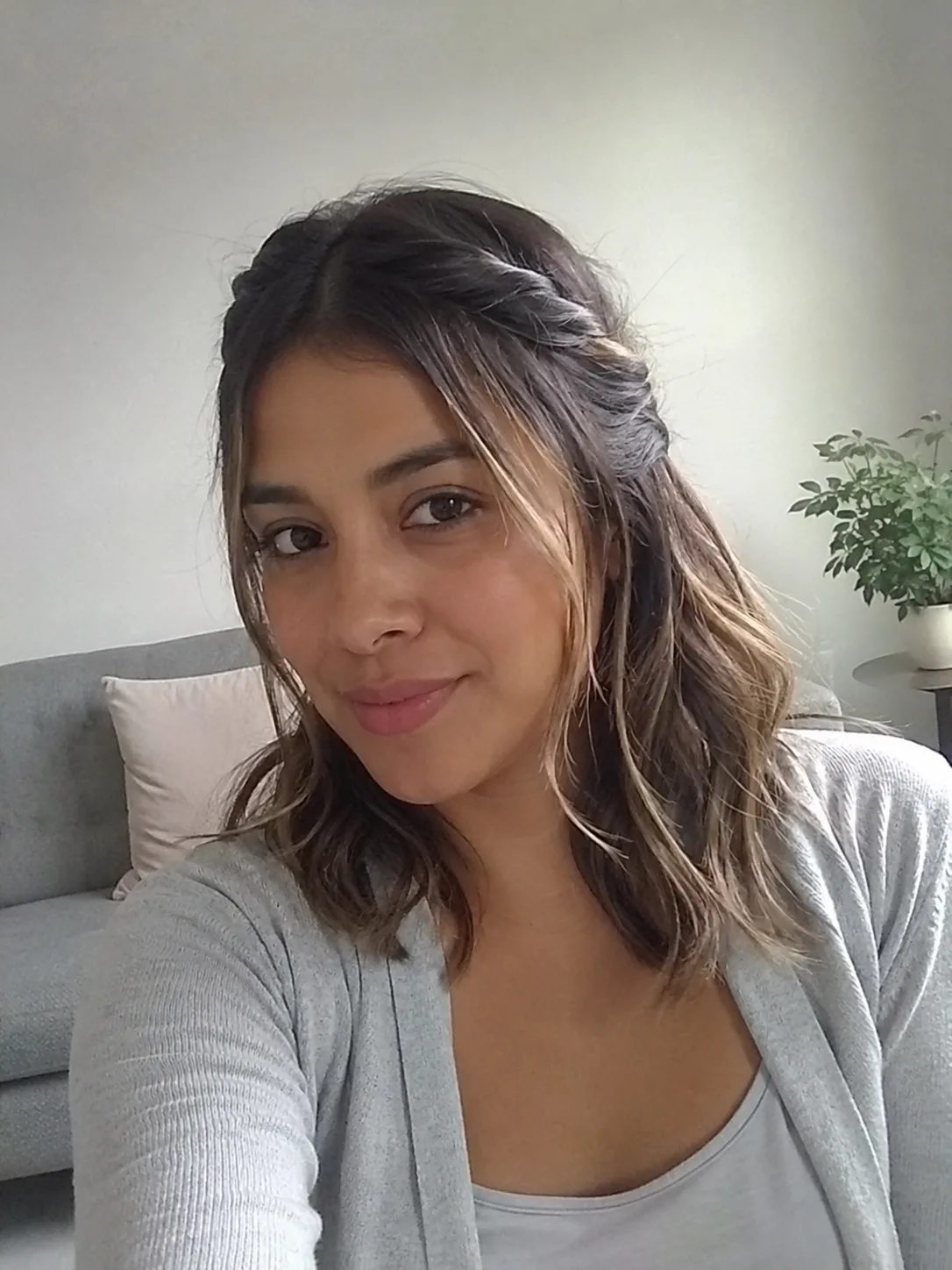 A woman with smooth, medium-length dark brown hair featuring a side-swept fringe and polished ends.