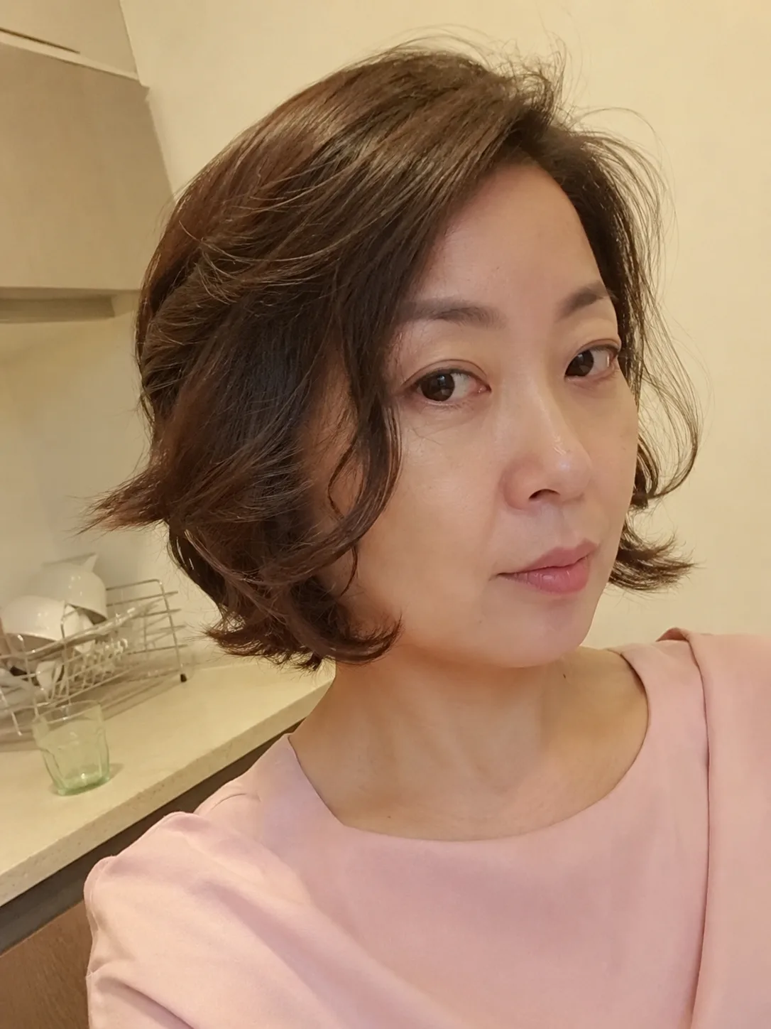 Braided crown wedding guest hairstyle with loose wavy hair down
