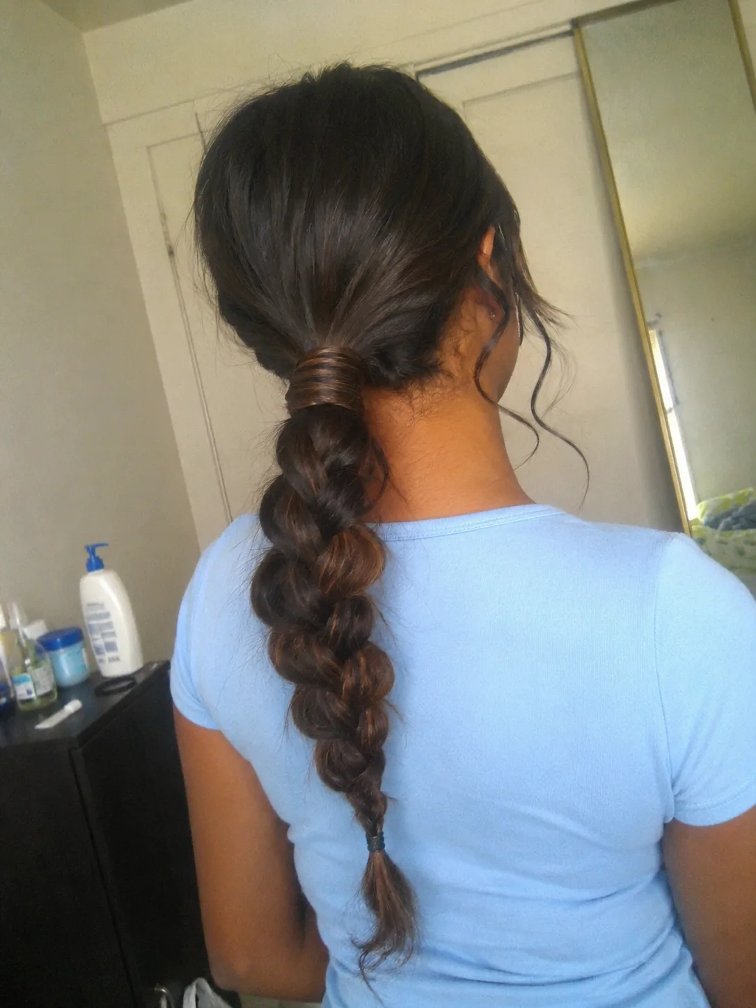 Braided low ponytail prom hairstyle for long hair with soft polished finish