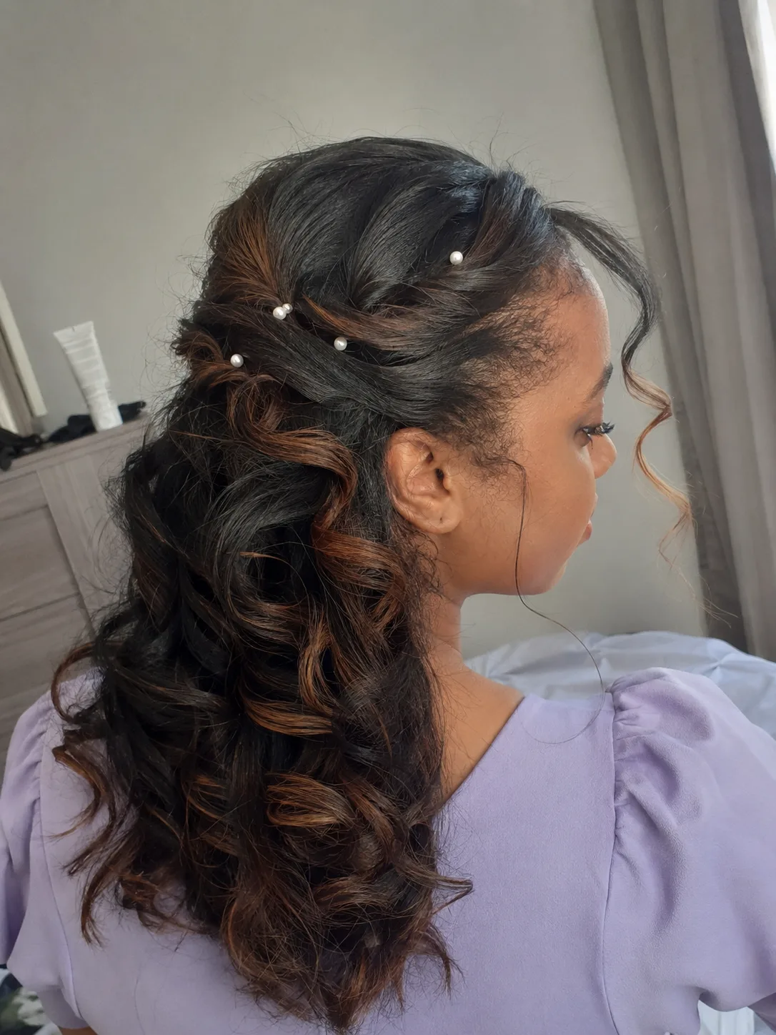 Bridesmaid hairstyles half up half down with deep side part and polished curls