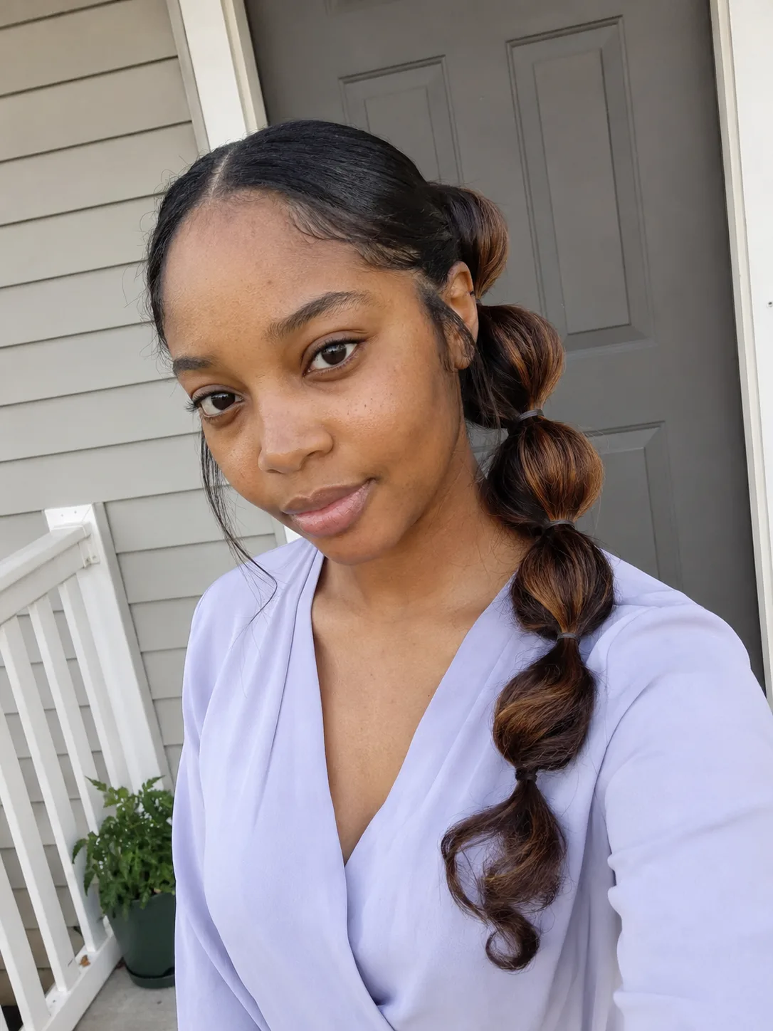 Bubble ponytail graduation hairstyle with smooth sections and curled ends