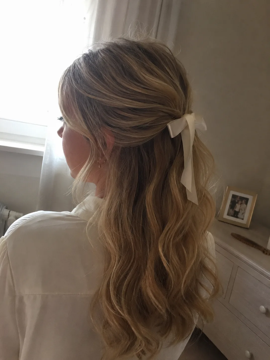 Close-up of a neat cross-pin hold point on thick blonde formal half-up hair