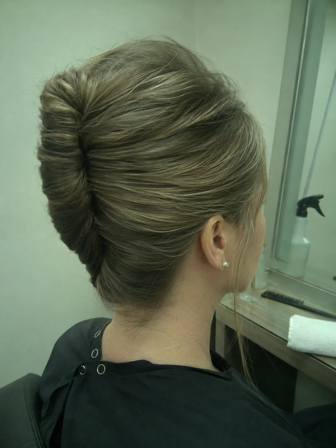 Close-up technical view of a tightly secured nape-level low wrap hairstyle on dark-brown hair