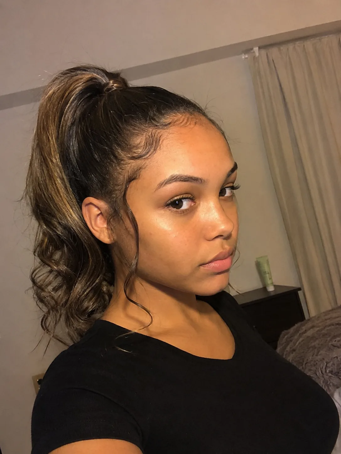 Crown braid prom updo with low textured bun and curled face-framing pieces
