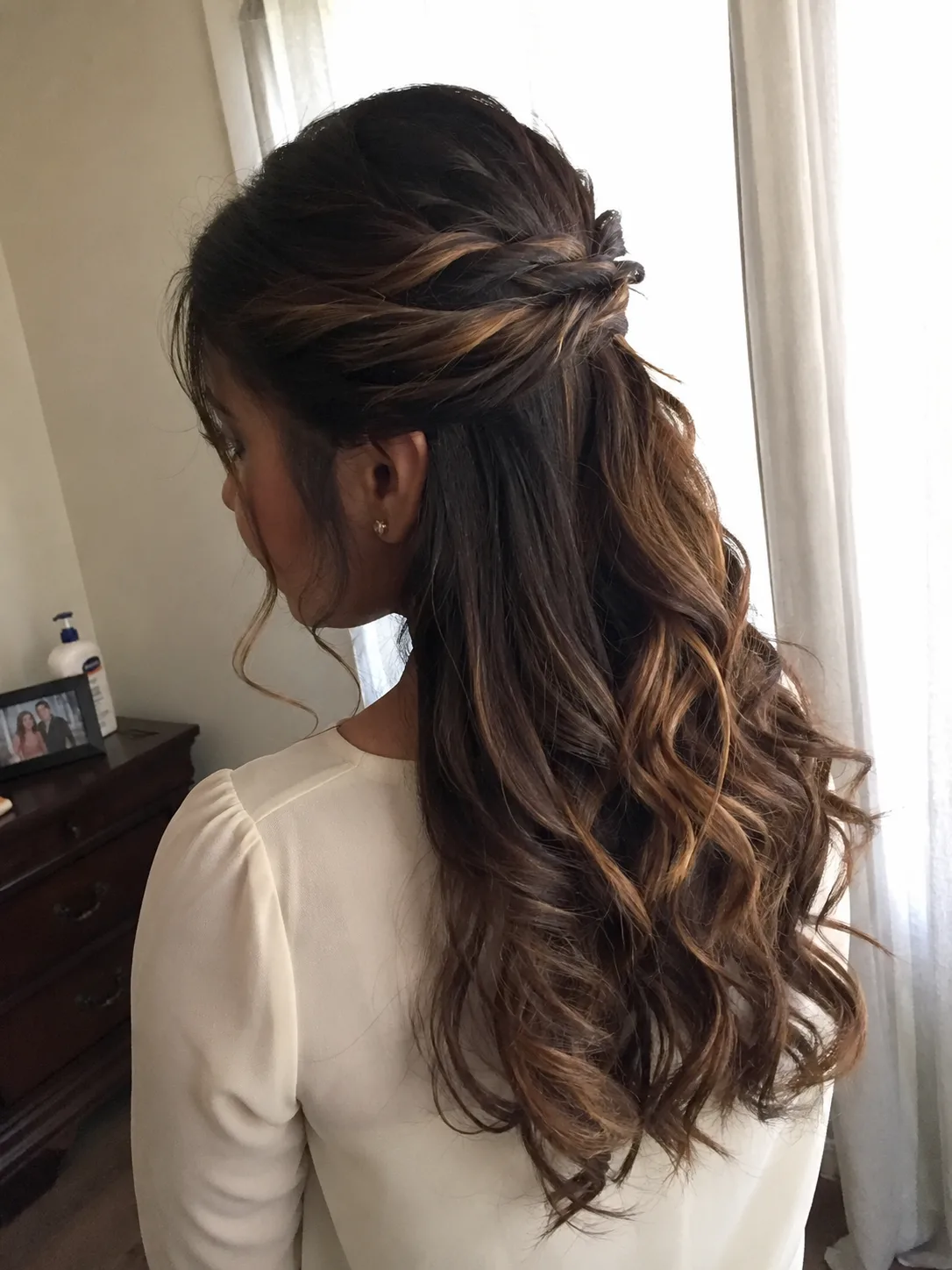 Delicate formal updo accented with small pearl sprig accessories nestled into secure twists