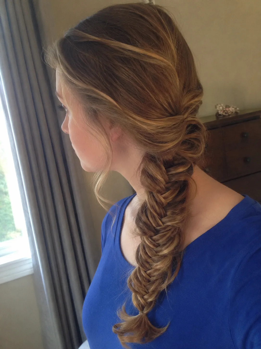 Glamorous side ponytail prom hairstyle with defined curls and smooth volume
