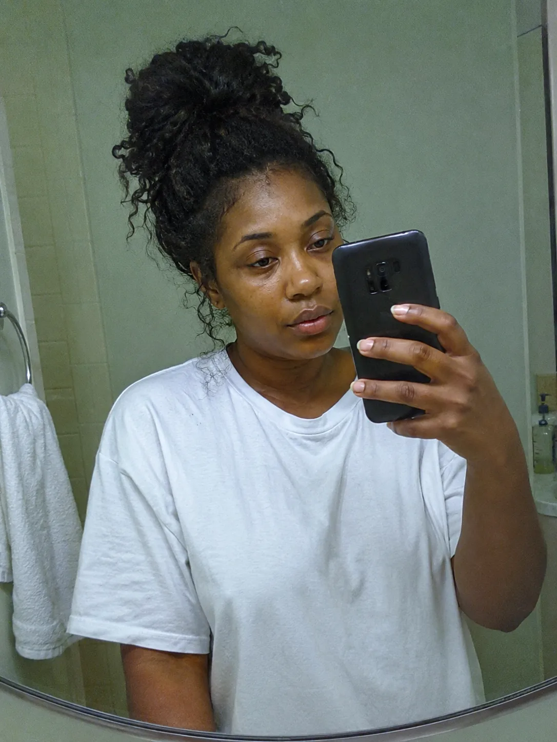 High messy beach bun with natural texture and loose face curls
