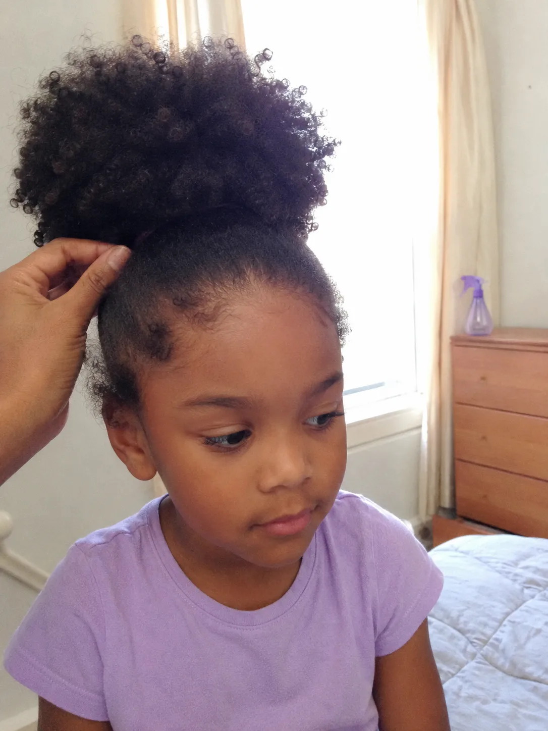 Intricate side-parted hair styling on a child showing clean elastic placement