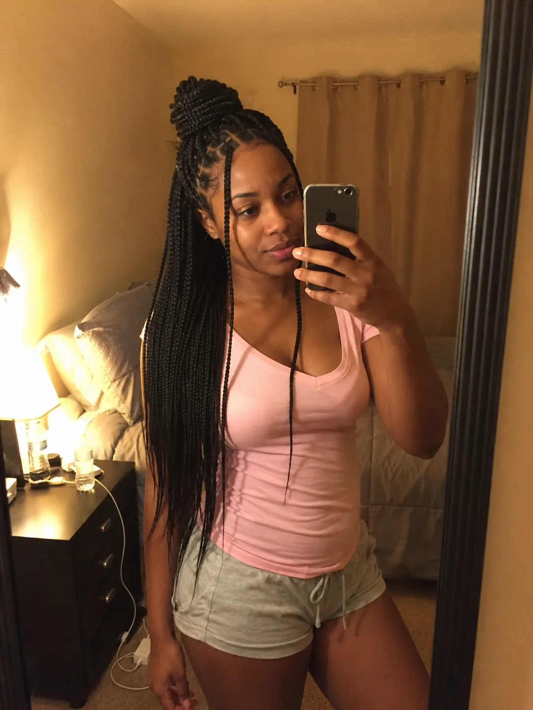 Long box braids styled half up in a high bun for summer maintenance