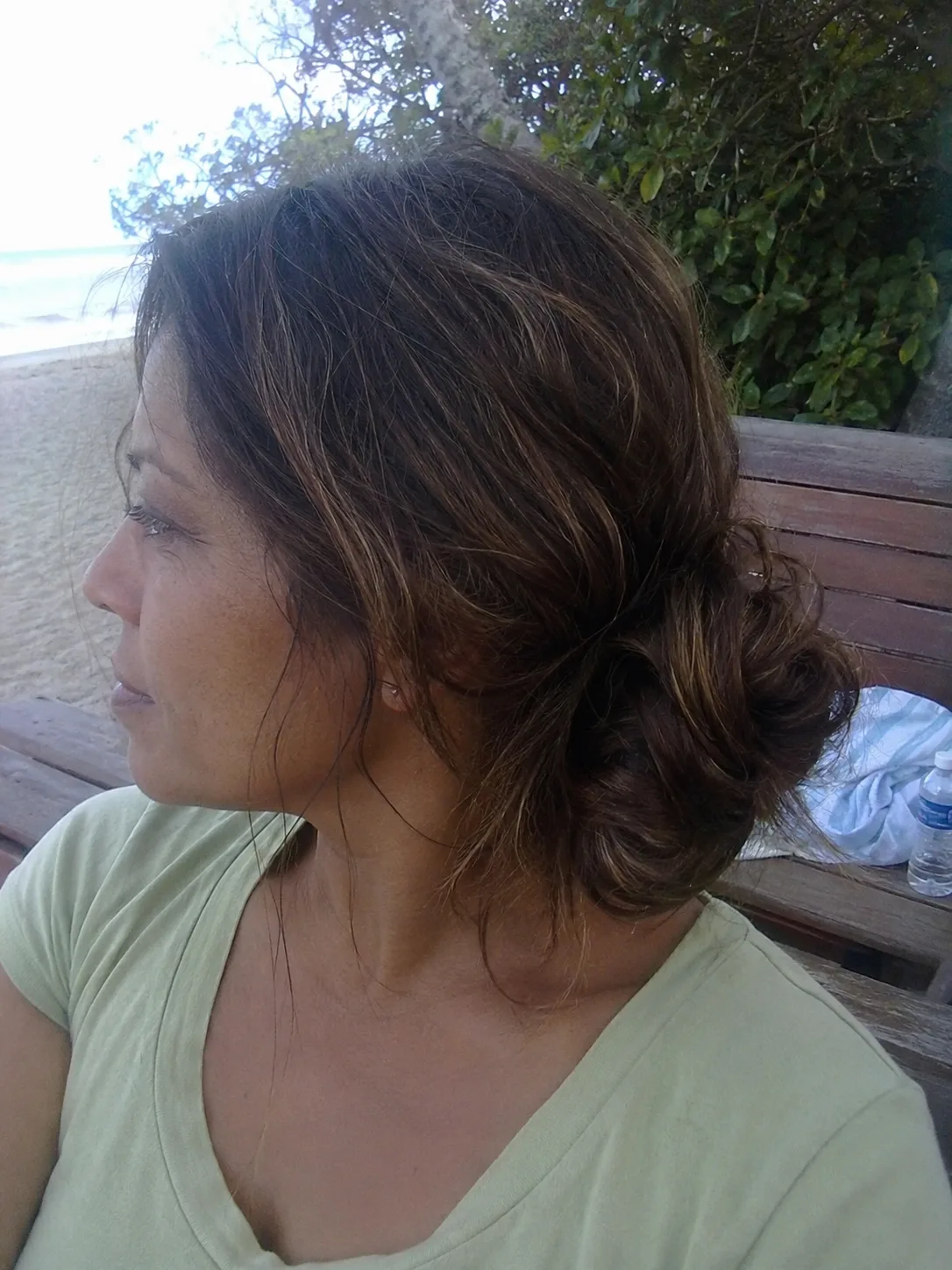 Loose low beach bun for long highlighted hair