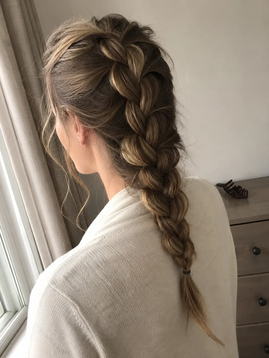 Loose summer braid hairstyle with soft highlighted hair.