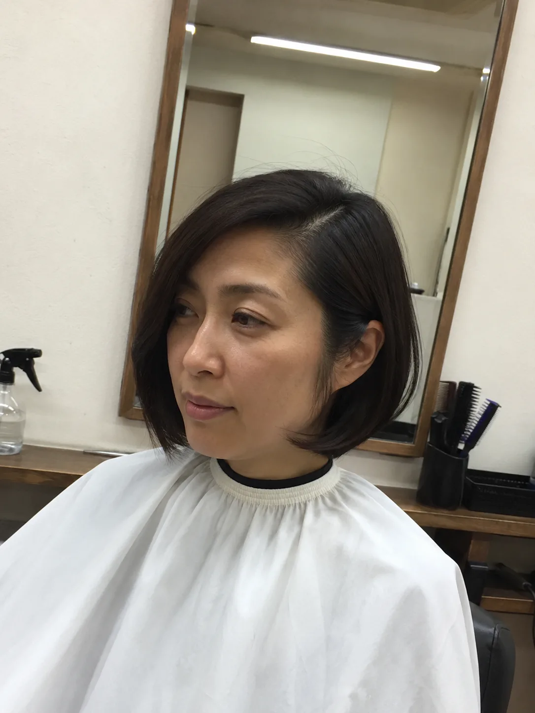 Low bun hairstyle in salon with hair products for summer buildup care