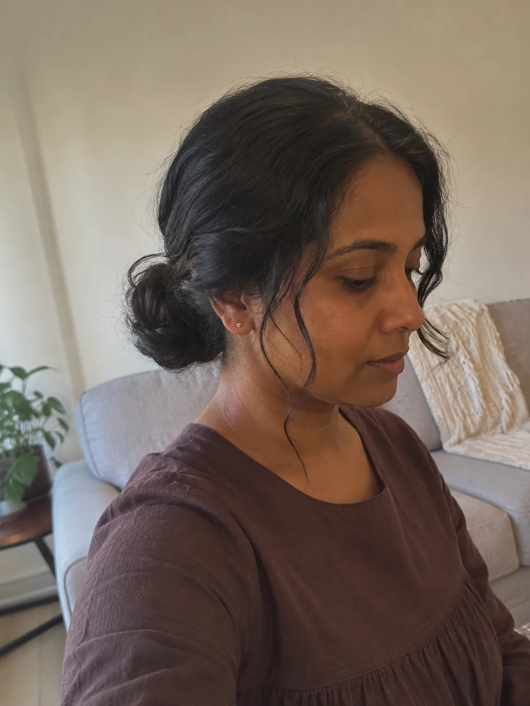 Low bun updo on long dark hair meticulously planned around a prominent headband accessory