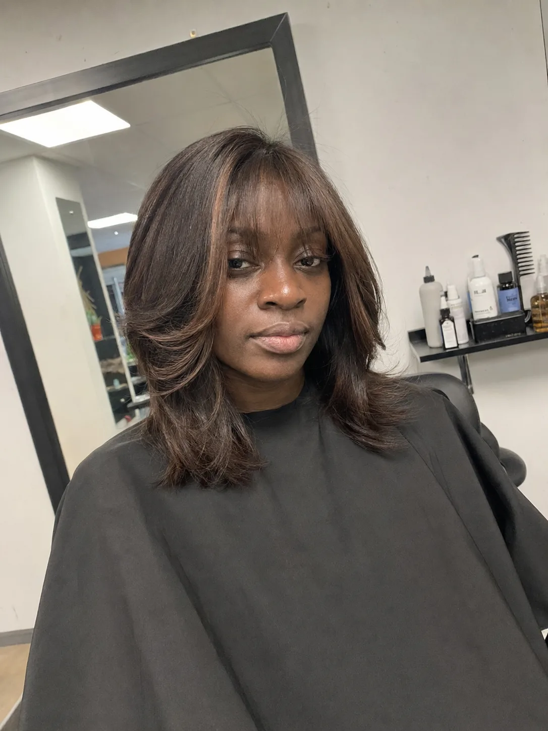 Medium-length wavy hair with curtain bangs and soft layers