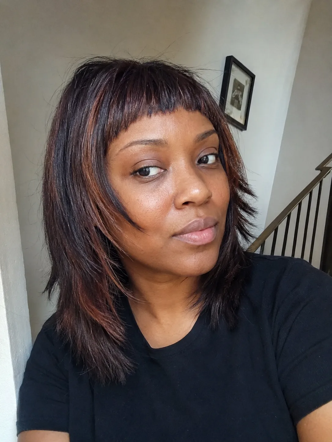 Straight medium-length hair with wispy bangs and layered ends