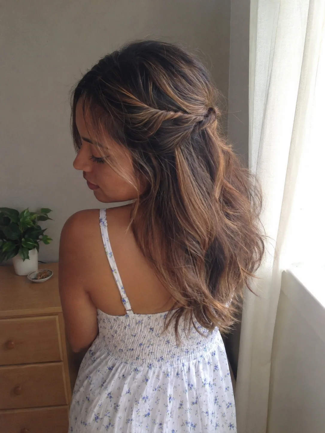 Messy high bun with loose face framing pieces for humid beach weather