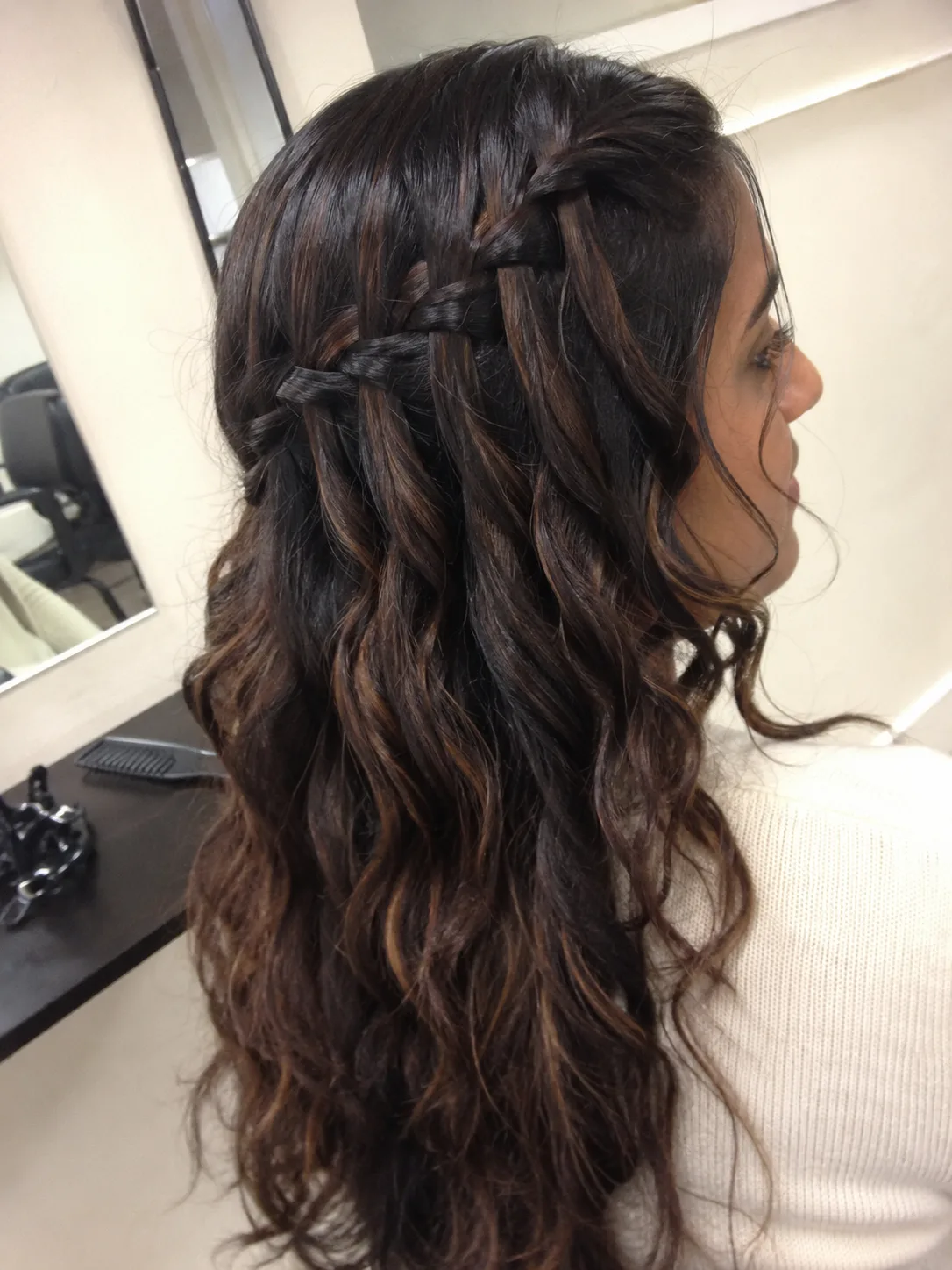 Mirror selfie of light brown wavy hair styled half up and accented with small delicate gold star hairpins