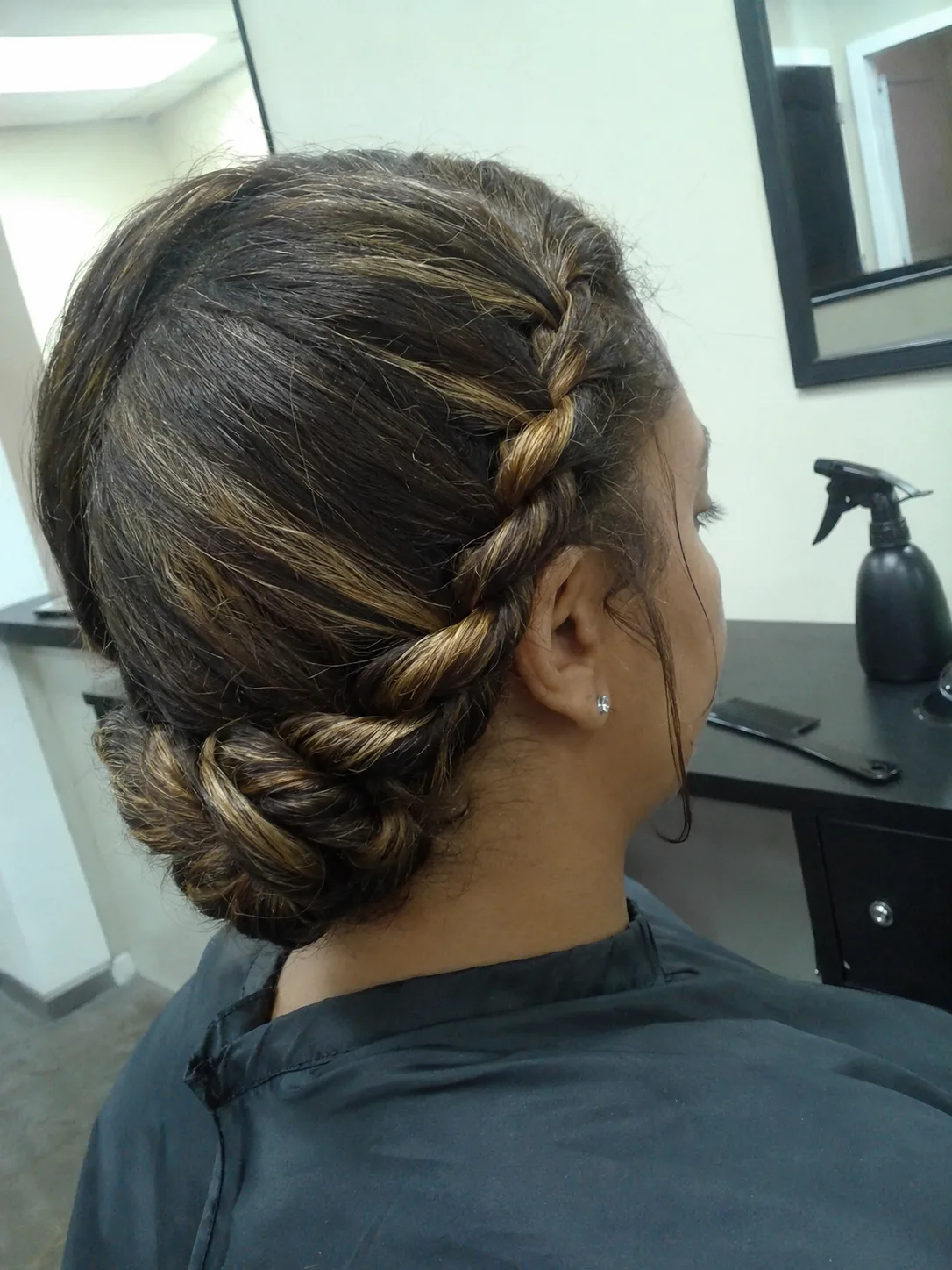 Modern textured formal updo combining soft bohemian accent braids with a loose low bun