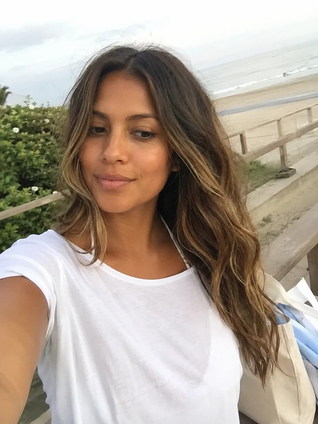 Natural loose beach waves with soft brunette highlights and salt-air texture near the ocean.