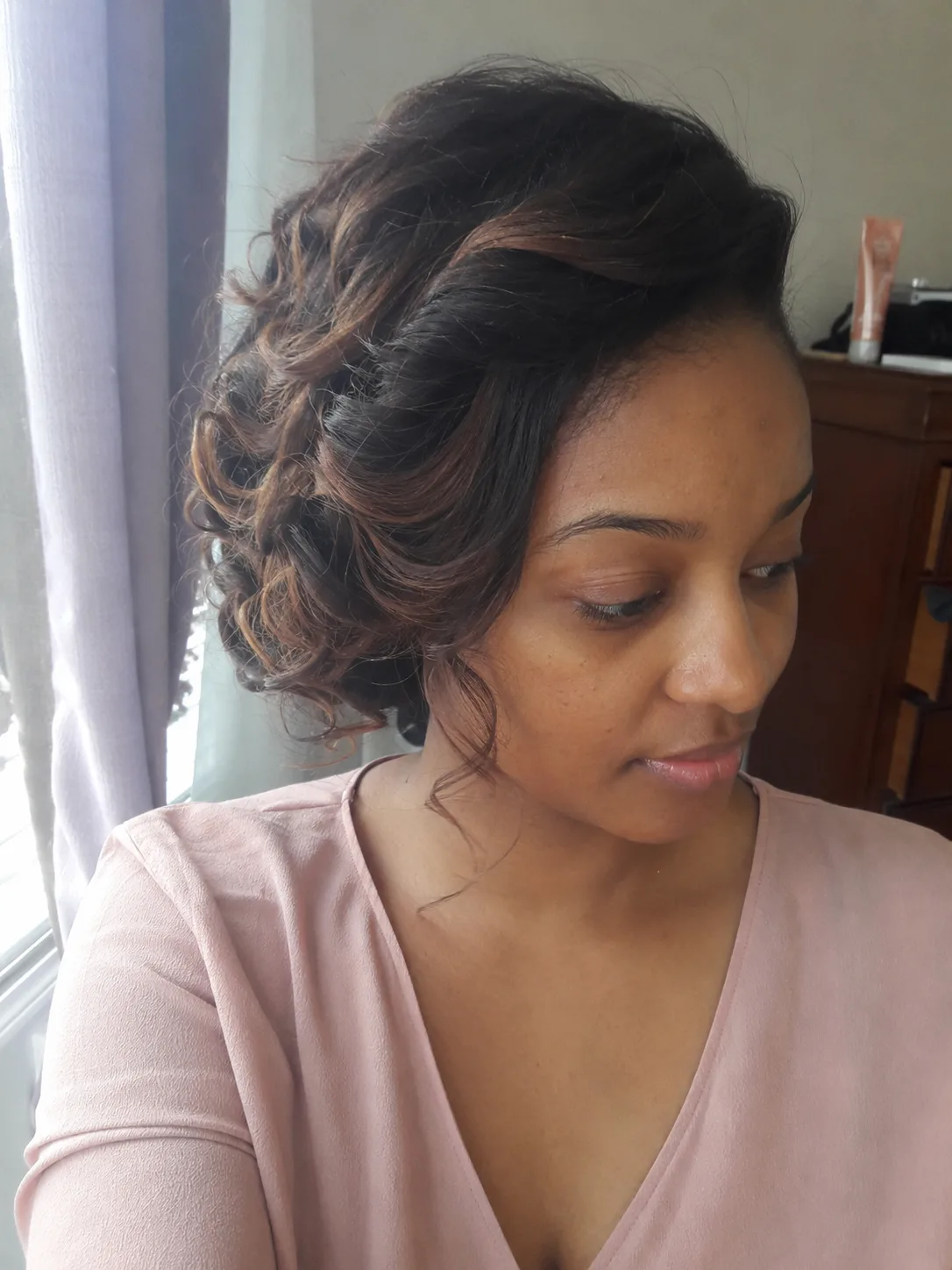 Romantic curled bridesmaid updo with soft side tendrils