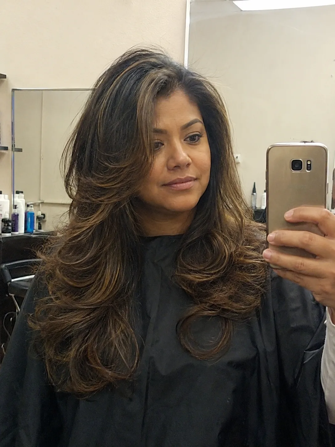 Salon blowout hairstyle with bouncy volume and layered brunette hair