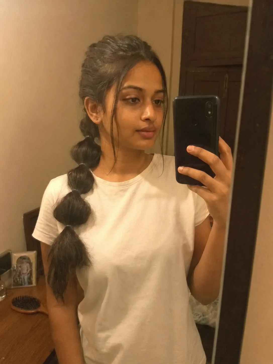 Satisfied salon client showing a unique custom tailored braided ponytail look from a three quarter angle