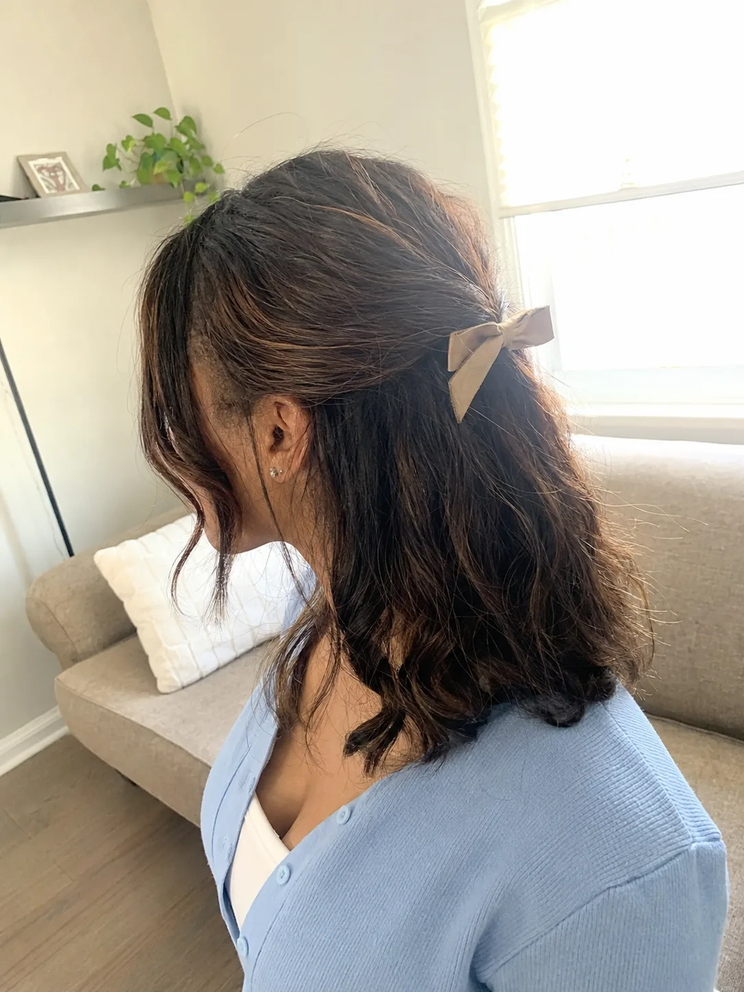 Shoulder-length wavy brown bob illustrating natural hair texture versus styled expectations