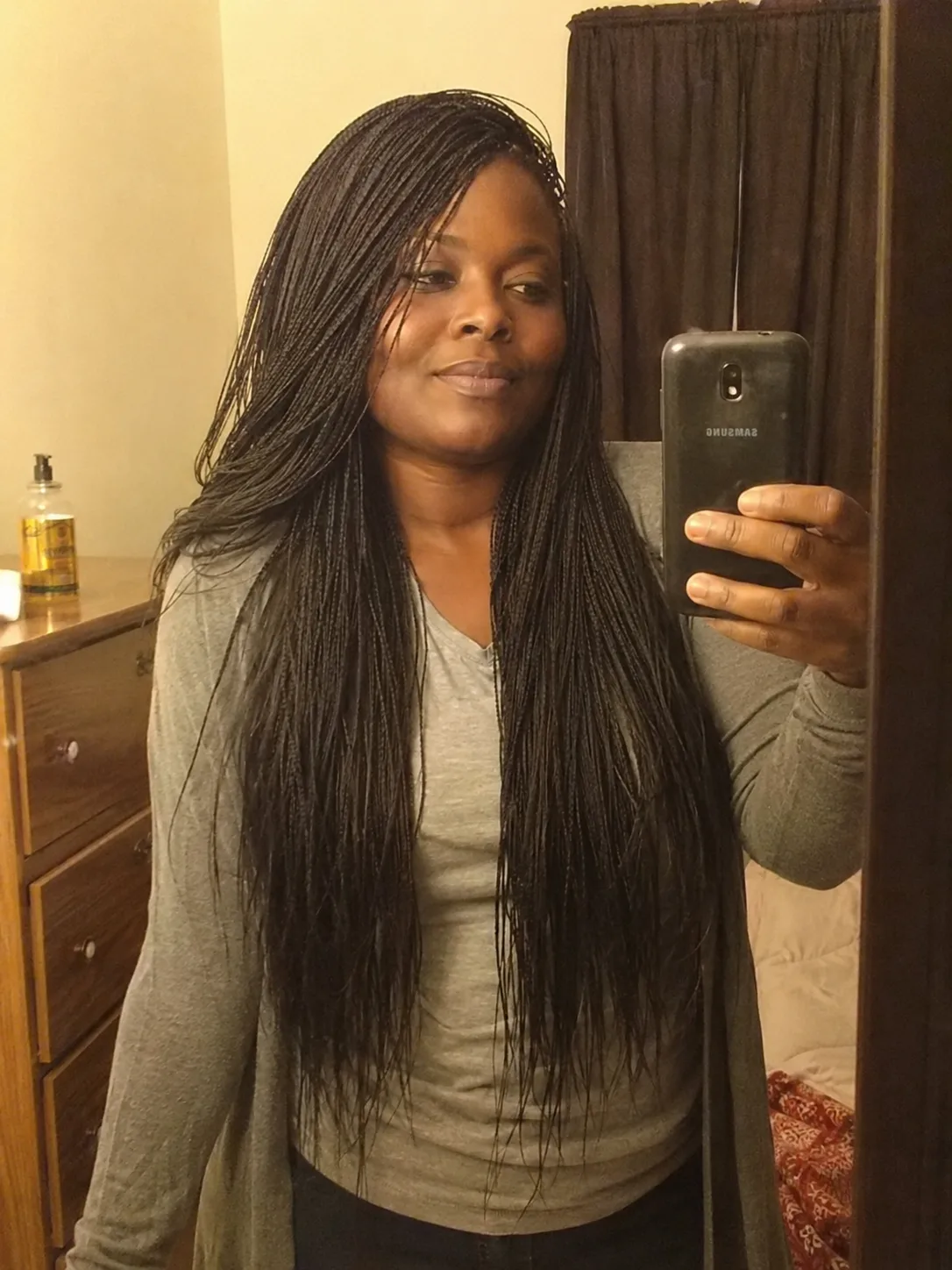 Side swept cornrow braids with long black braids styled over one shoulder