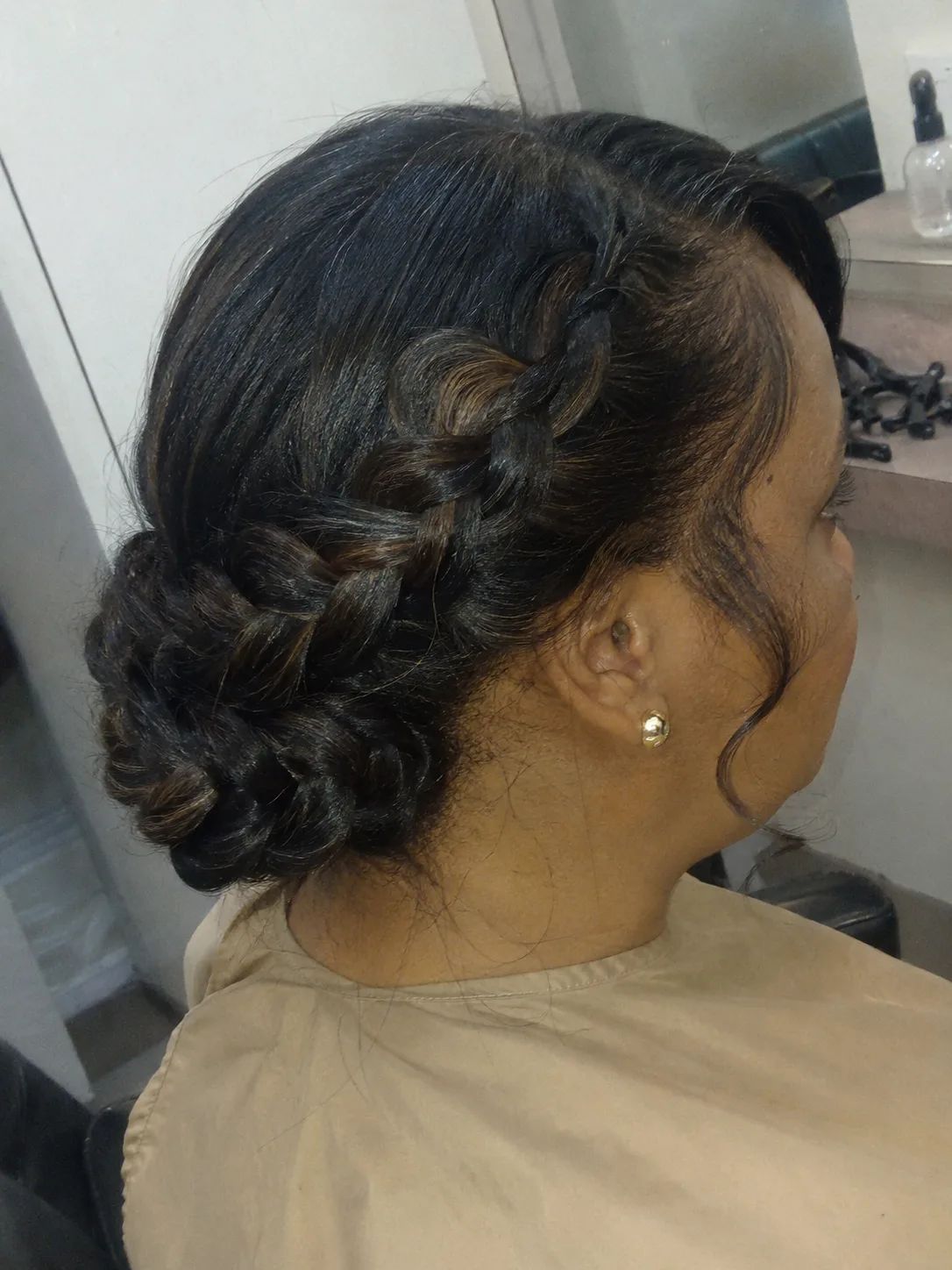 Side-view profile of an elegant, low-sitting smooth formal chignon bun on warm blonde hair.
