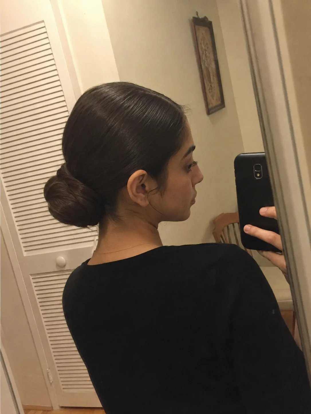 Sleek low bun prom hairstyle for long hair with smooth polished finish