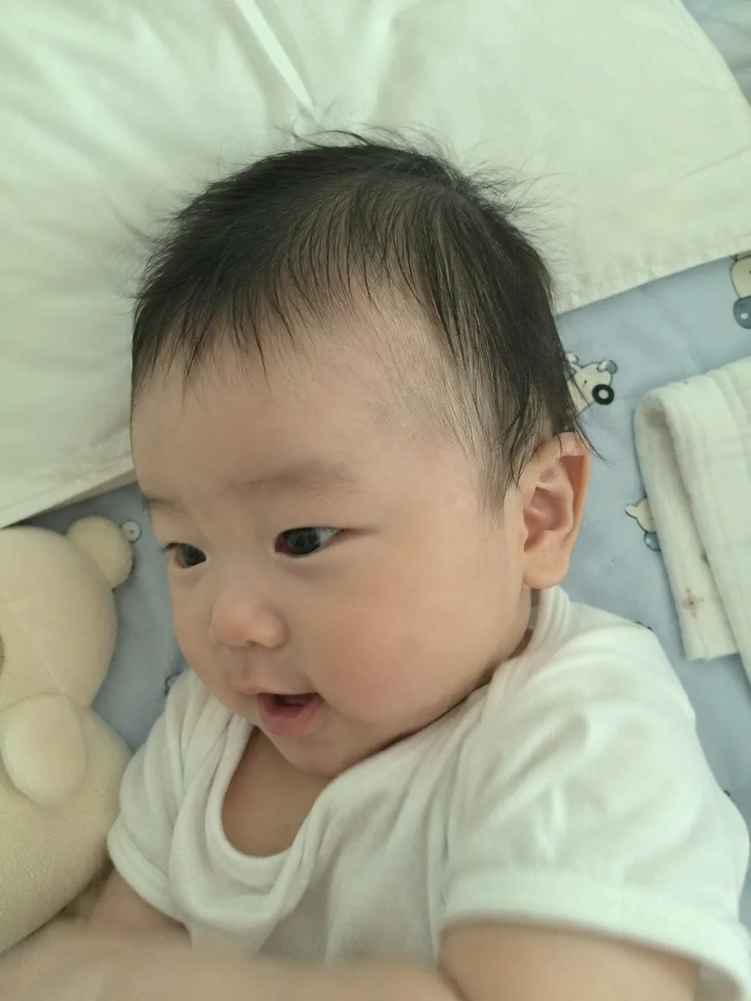 Soft fabric tie looped once around a small bundle of fine baby hair to prevent tension